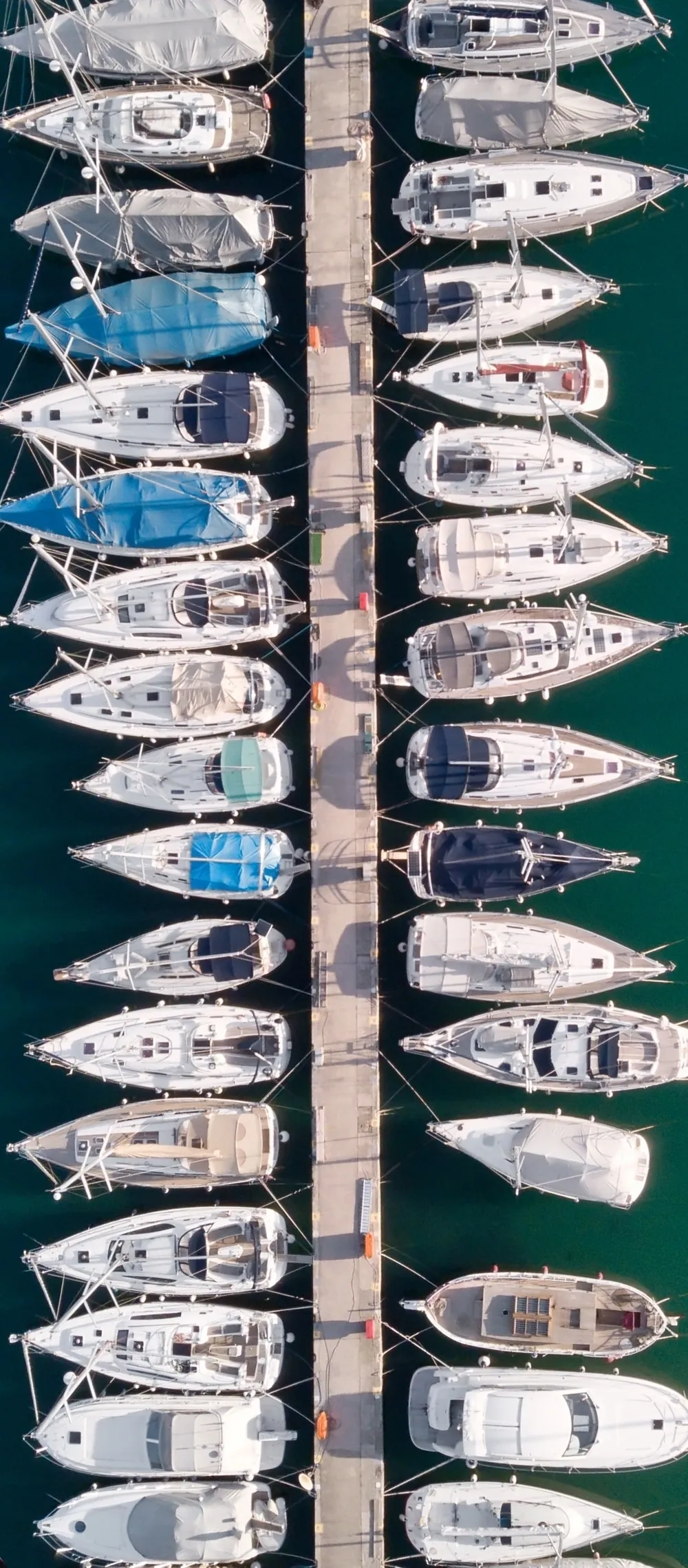 Boats docked along a marina pier, seen from above
