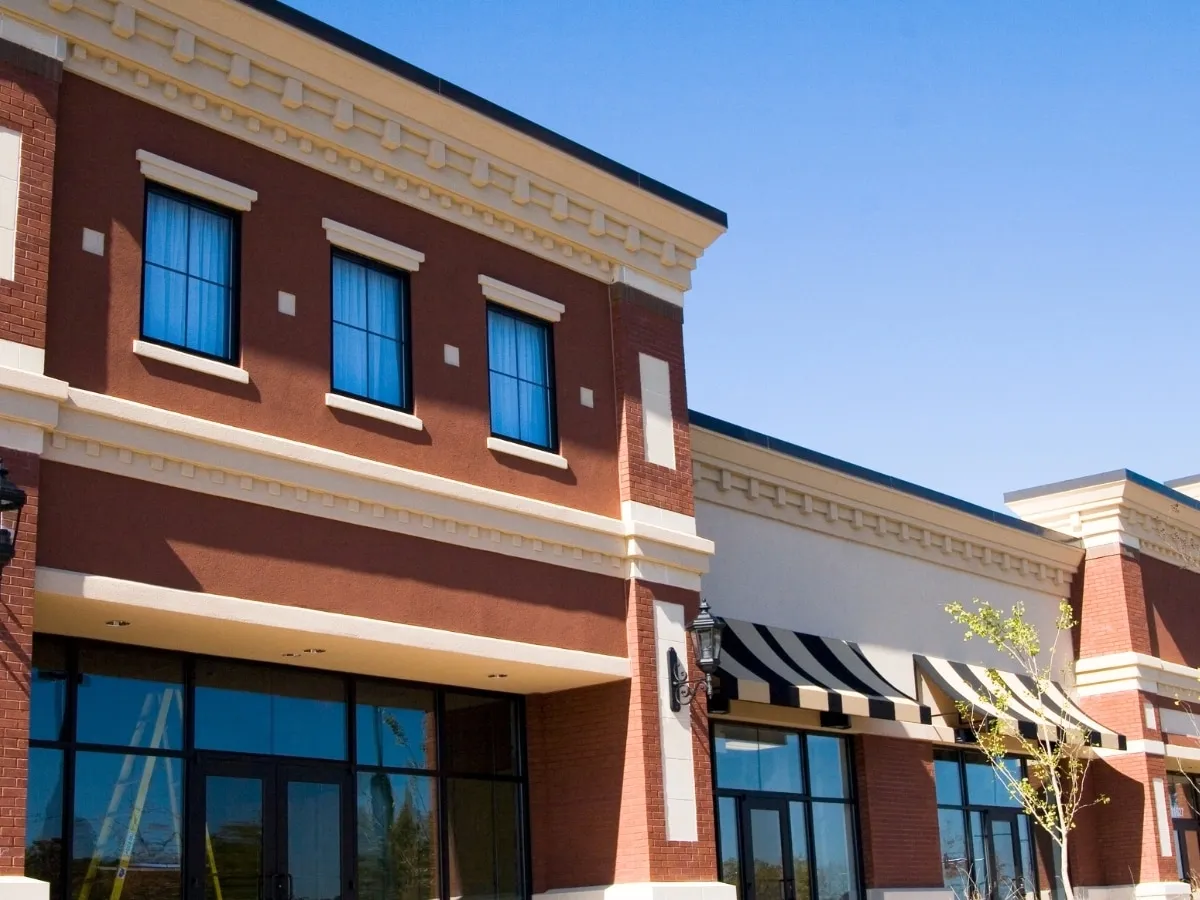 A row of brick storefronts with striped awnings